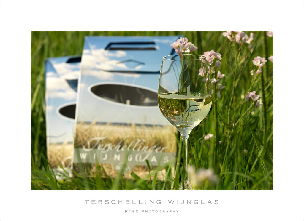 Wine glass and packaging photographed among wildflowers